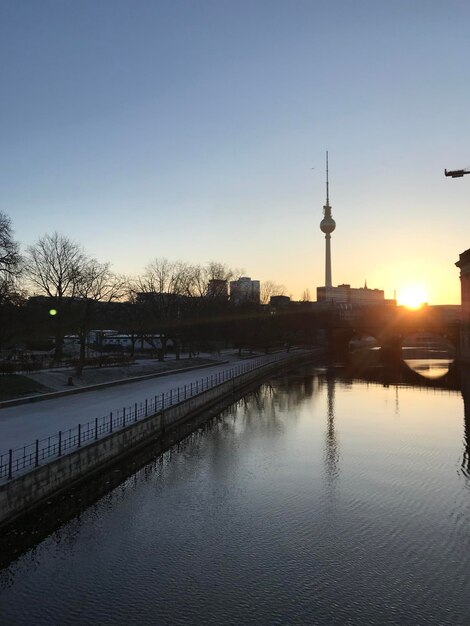 Foto blick auf den fluss von gebäuden gegen den himmel bei sonnenuntergang