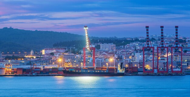 Blick auf den Hafen von Lissabon mit Schiff und Hafenkränen am Abend