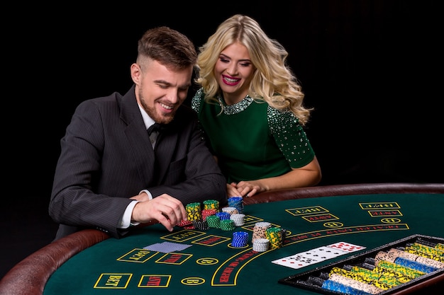 Blick auf den jungen, selbstbewussten Mann mit der Dame, während er Poker spielt.