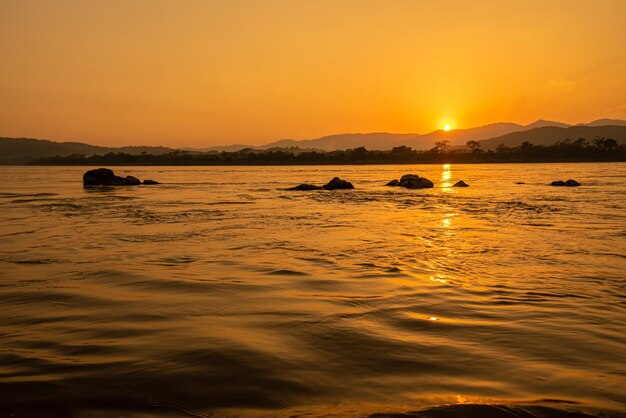 Foto blick auf den morgendlichen mekong, umgeben von bergen und gelben sonnenstrahlen im sonnenuntergang