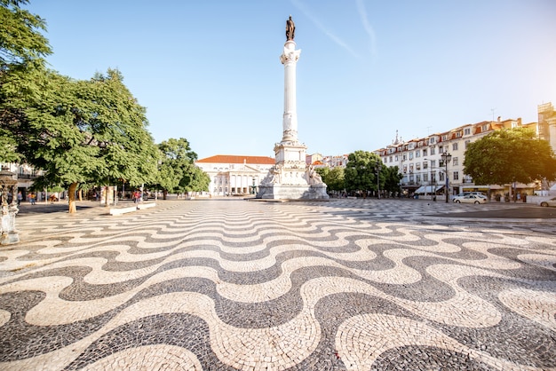 Blick auf den Rossio-Platz mit Säulendenkmal während des Sonnenaufgangs in Lissabon, Portugal