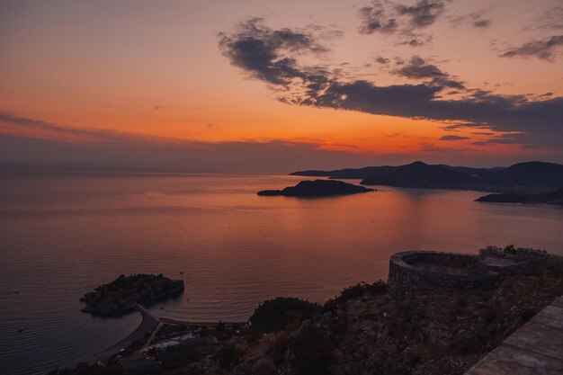 Blick auf den schönen Sonnenuntergang über Sveti Stefan, eine kleine Insel und Ferienort in Montenegro, Balkan, Adria, Europa