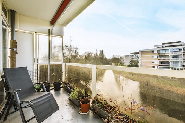 Blick auf den See vom Balkon mit bequemem Stuhl und malerischen Pflanzen