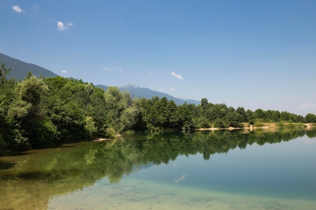 Blick auf den See zwischen Wald und Bergen in Bulgarien an einem sonnigen Sommertag