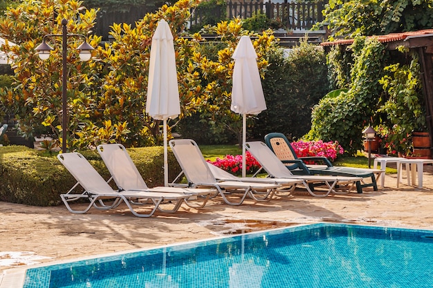 Blick auf den Sitzbereich des Hotels mit Sonnenschirmen und Sonnenliegen am Pool