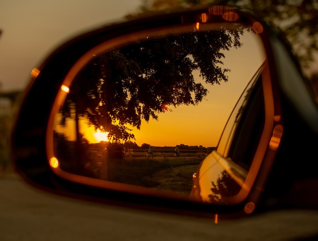 Blick auf den Sonnenuntergang im Autospiegel