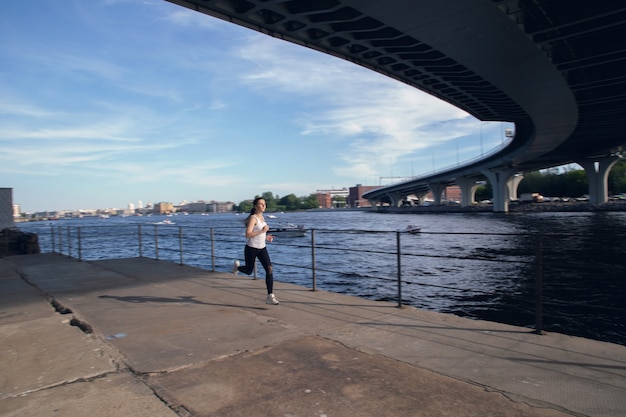 Blick auf den Sportler beim Joggen entlang der Böschung