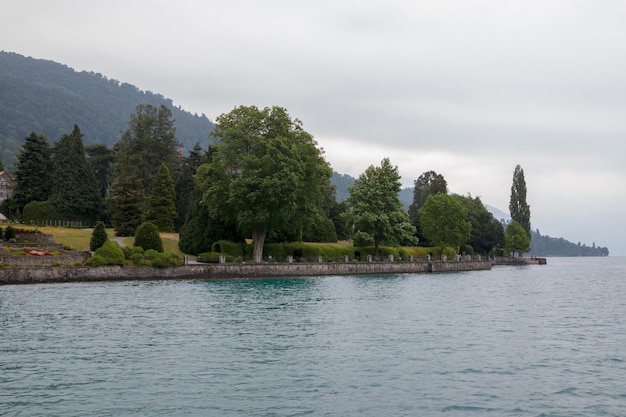 Blick auf den Thunersee und die Berge vom Schiff in der Stadt Spiez, Schweiz, Europa. Sommerlandschaft. Dramatische stimmungsvolle blaue Wolkenszene