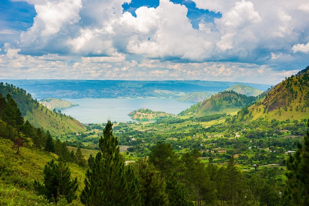 Blick auf den Tobasee und die Insel Samosir von oben auf Sumatra Indonesien. Riesige vulkanische Caldera, bedeckt von Wasser, grünen Reisfeldern, Äquatorialwald.