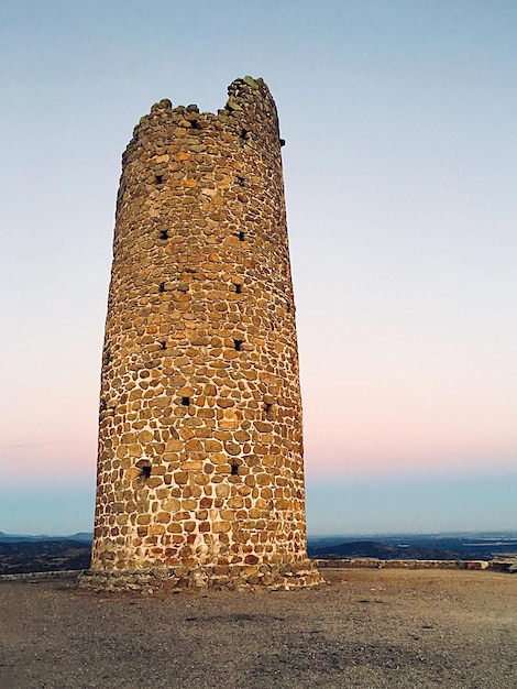 Foto blick auf den turm vor dem meer bei sonnenuntergang