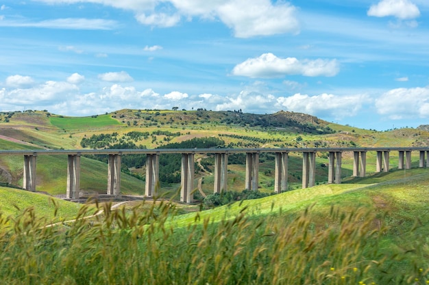 Blick auf den Viadukt der Autobahnbrücke im Tal zwischen der Verkehrsinfrastruktur der grünen Hügel