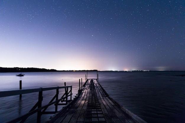 Foto blick auf die anlegestelle im ruhigen meer bei nacht