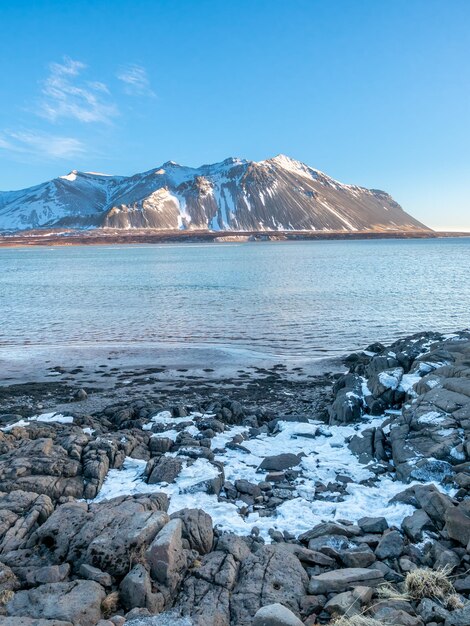 Blick auf die Berge, das Meer und die Küste in der Wintersaison unter blauem Himmel in Island