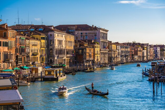 Blick auf die Fassaden malerischer Altbauten am Canal Grande Gondeln und Boote in Venedig Sonniger Sommertag mit blauem Himmel