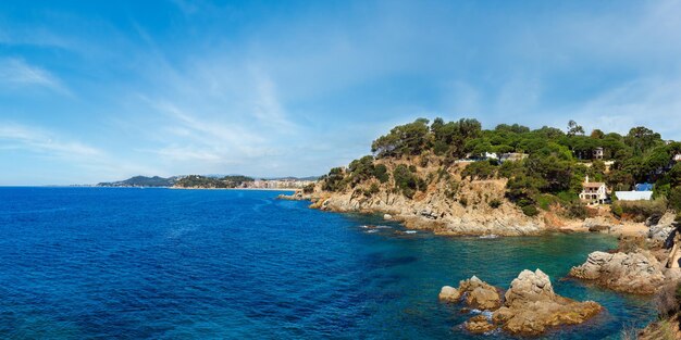 Blick auf die felsige Küste des Sommermeers in der Nähe der Stadt Lloret de Mar, Katalonien, Spanien. Menschen nicht wiederzuerkennen