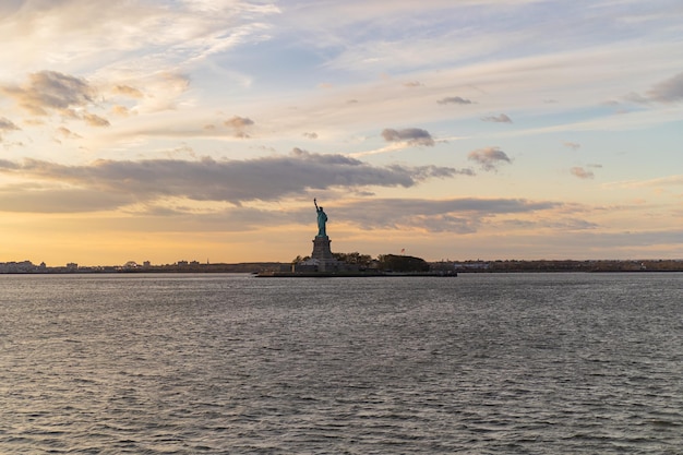 Blick auf die Freiheitsstatue aus dem Wasser bei Sonnenuntergang, New York, USA