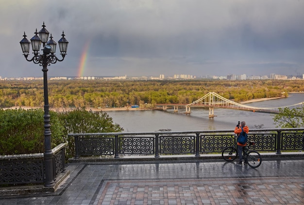 Blick auf die Fußgängerbrücke „Brücke und Regenbogen“ und den Fluss Dnjepr von oben über Kiew