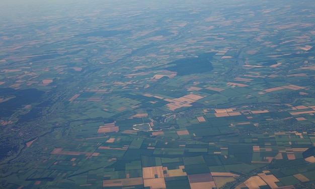 Blick auf die Landoberfläche aus einem Fenster des Flugzeugs, das in großer Höhe fliegt