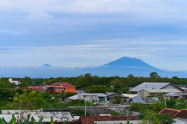 Blick auf die Landschaft des majestätischen Vulkans Agung über den Dächern der Stadt an seinem Fuß
