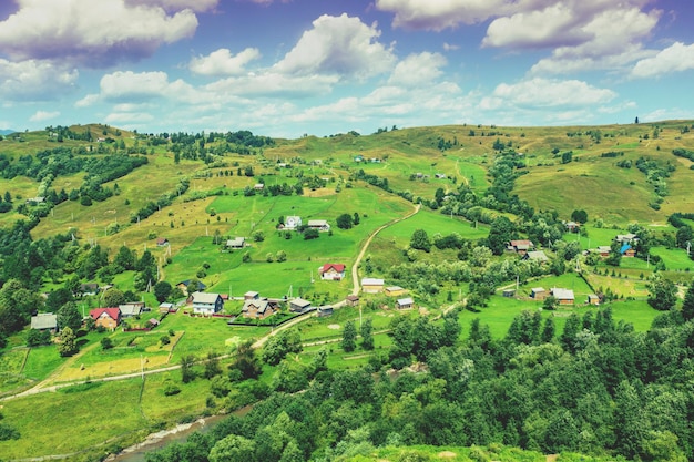 Blick auf die Landschaft im Sommer Dorf auf den Hügeln mit schönem bewölktem Himmel