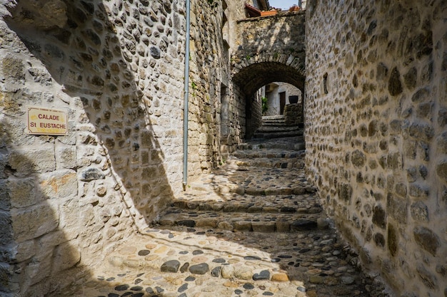 Blick auf die schmale, aber schöne Kopfsteinpflasterstraße des mittelalterlichen Dorfes Lanas in der Ardèche