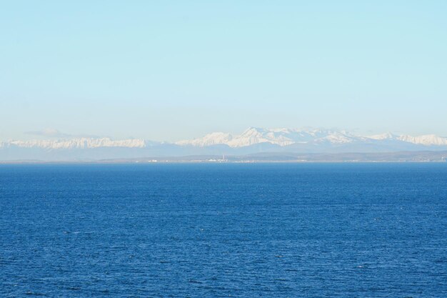 Blick auf die schneebedeckten Alpenberge gegen die blaue Adria und den Himmel. Winterferien. Slowenien