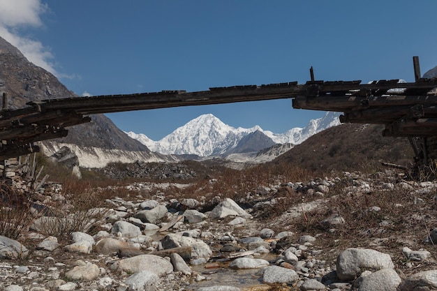 Blick auf die schneebedeckten Berge vom Tal mit einer schwachen Brücke. Himalaya, Manaslu, Bimthang