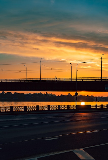 Blick auf die Silhouette der Brücke und die Spiegelung des Sonnenuntergangs im Fluss Abendansicht