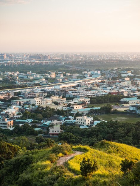 Foto blick auf die stadt vom wunderschönen berg aus blauer himmel und grüne wiese