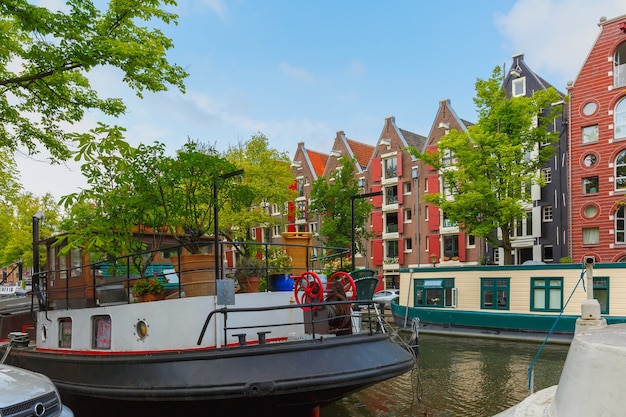 Blick auf die Stadt von Amsterdam-Kanal mit malerischen Hausbooten und typischen Häusern, Holland, Niederlande.