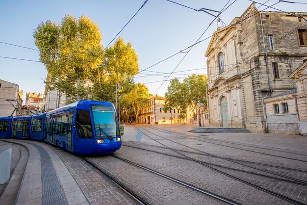 Blick auf die Straße mit Saint-Charles-Kapelle und Straßenbahn während des Sonnenuntergangs in der Stadt Montpellier in Südfrankreich