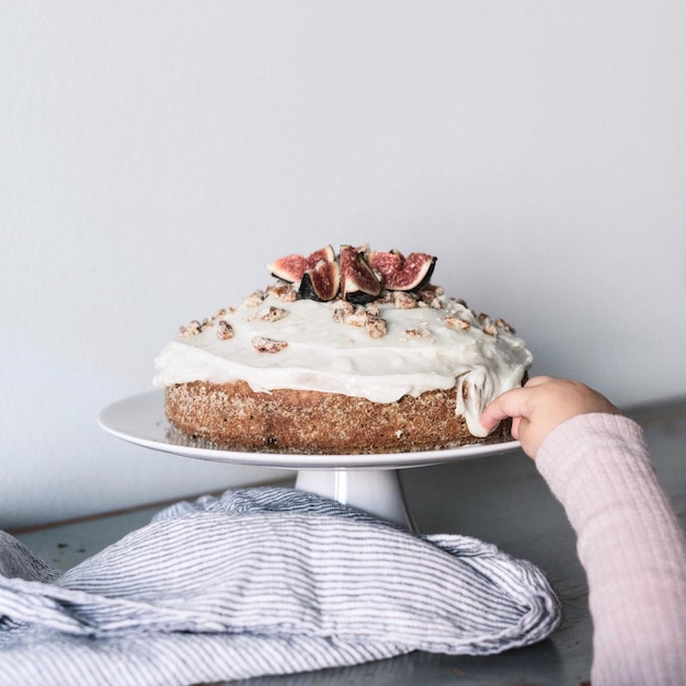 Blick auf ein junges Mädchen, das Glasur aus einem Kuchen schmeckt