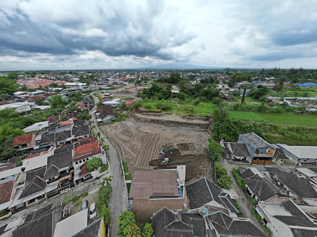 Blick auf ein Wohngebiet mit einem großen Erdhaufen und Häusern im Hintergrund.