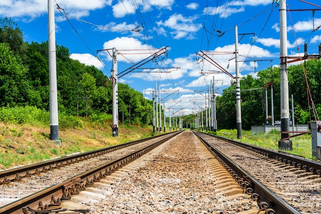 Blick auf eine Bahnstrecke und weiße Wolken am blauen Himmel