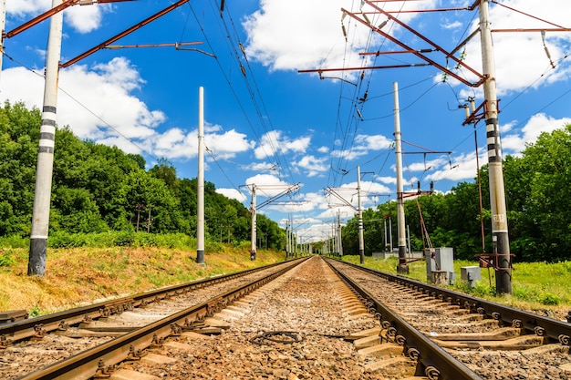 Blick auf eine Bahnstrecke und weiße Wolken am blauen Himmel