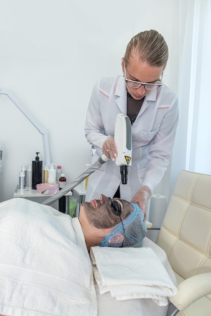 Blick auf eine Frau mit kosmetischer Gesichtsmaske, die im Spa-Center auf dem Bett liegt