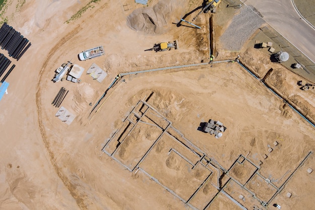 Blick auf eine große Baustelle, auf der Erdbewegungsmaschinen den Boden zum Verlegen von unterirdischen Rohrleitungsgebäuden bilden.