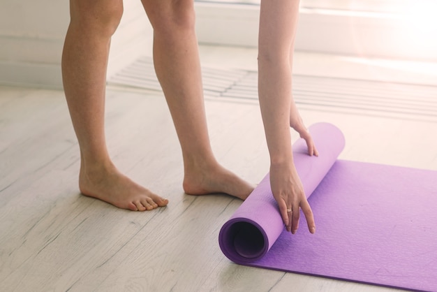 Blick auf eine schöne junge Frau, die im luxuriösen Fitnesscenter trainiert, Yoga oder Pilates macht.