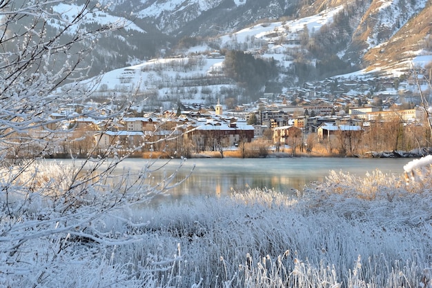 Blick auf eine Stadt von Savoyen, Bourg Saint Maurice, am Ufer eines Flusses mit gefrorenen Bäumen und Pflanzen