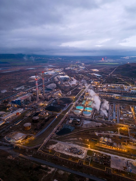 Blick auf eine stark rauchende Fabrik bei Nacht Luftaufnahme des Industriegebiets