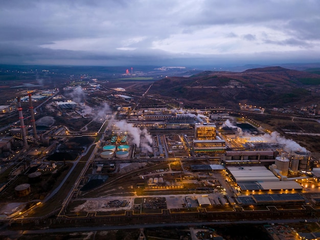 Blick auf eine stark rauchende Fabrik bei Nacht Luftaufnahme des Industriegebiets