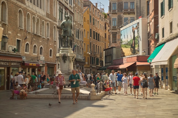 Blick auf einen kleinen Platz in Venedig (insbesondere Bortolomio-Feld), der im Sommer mit Touristen überfüllt ist.