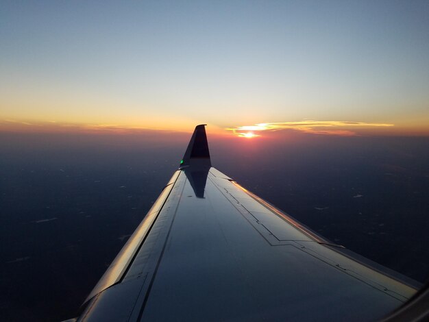 Foto blick auf flugzeugflügel gegen den himmel bei sonnenuntergang