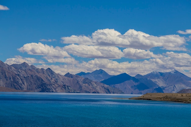 Blick auf majestätische felsige Berge gegen den blauen Himmel und den Pangong-See im indischen Himalaya, Ladakh-Region, Jammu und Kaschmir, Indien. Natur- und Reisekonzept