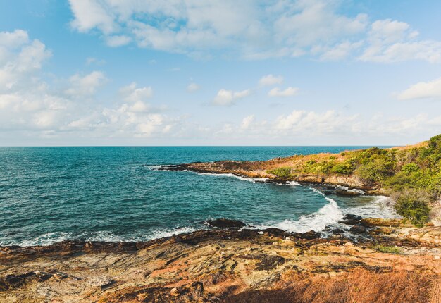 Blick auf Meereswellen und fantastische felsige Küstenlandschaft - tropische Insel der Seestückfelsen mit Ozean und blauem Himmel in Thailand