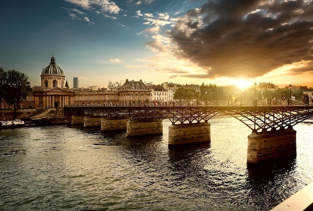 Blick auf Pont des Arts und Institut de France in Paris bei Sonnenuntergang