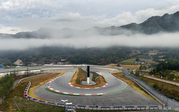 Blick auf Rennstreckenasphalt mit Kurve der Rennstrecke im nebligen Tal