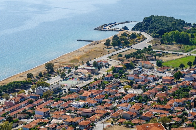 Blick auf Stratonion von der Drohne, mehrere Gebäude mit roten Dächern auf Ägäis kosten, viel Grün und Spielplätze, Griechenland