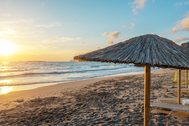 Blick auf tropischen Strand mit Sonnenschirmen während des Sonnenuntergangs