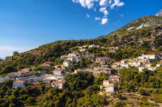 Blick auf weiße Häuser mit gelben Fensterläden, Berge und Meer vuno albania